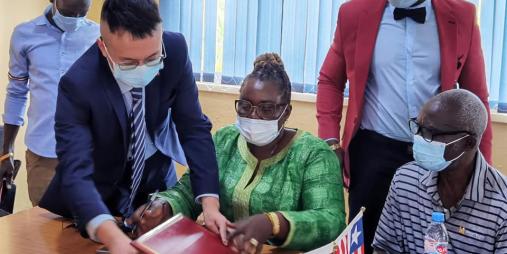 Acting Minister Ruth C. Collins (center) at the signing ceremony.